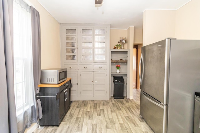 kitchen with stainless steel appliances, a healthy amount of sunlight, and light wood finished floors