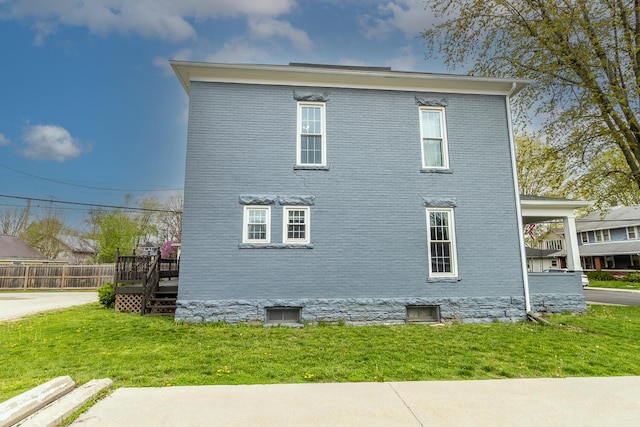 view of property exterior featuring brick siding and a lawn