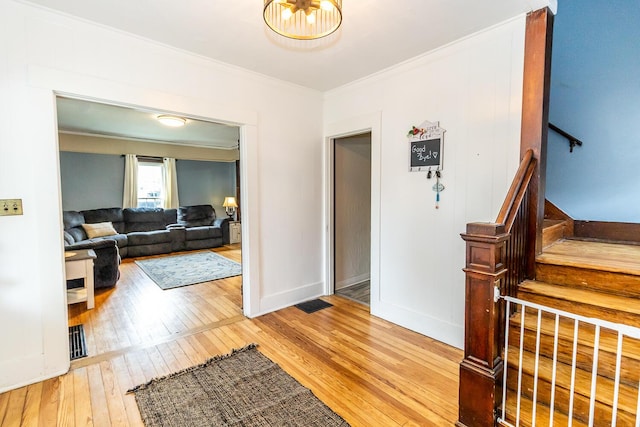 foyer entrance featuring stairs, wood-type flooring, baseboards, visible vents, and crown molding