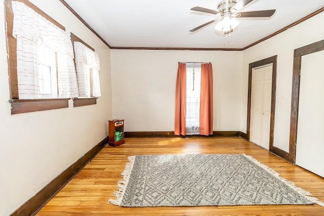 unfurnished bedroom featuring hardwood / wood-style floors, baseboards, and crown molding