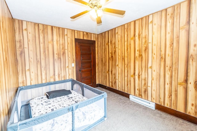 bedroom with ceiling fan, wood walls, carpet floors, and visible vents