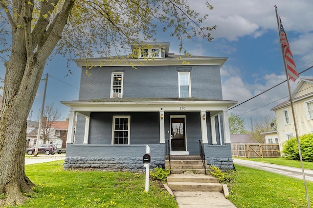 traditional style home featuring a front yard and brick siding