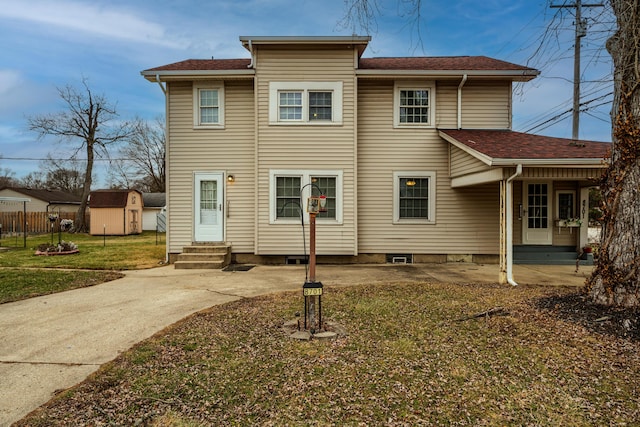 view of front of house featuring a storage shed and a front yard