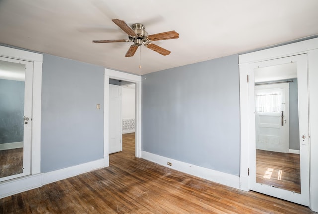 unfurnished bedroom with wood finished floors, baseboards, and ceiling fan