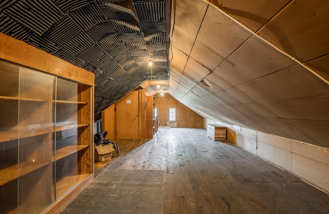 additional living space with wood-type flooring and vaulted ceiling