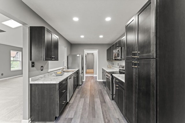 3667 Randee Ln, Springfield, OH 45502 - kitchen featuring appliances with stainless steel finishes, light wood-style floors, light stone counters, recessed lighting, and dark cabinets