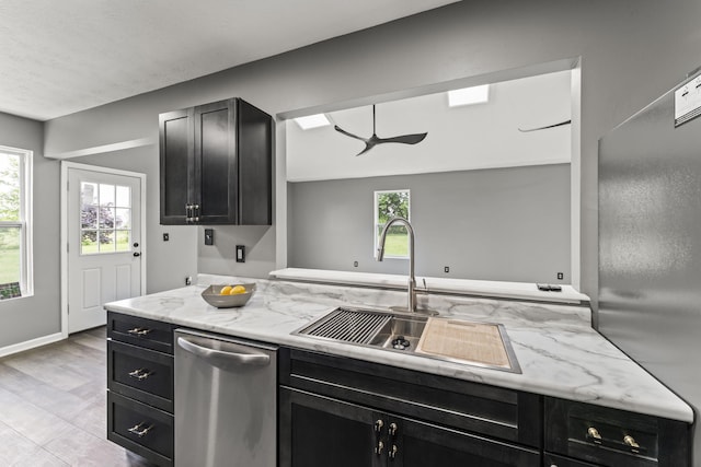 3667 Randee Ln, Springfield, OH 45502 - kitchen with dark cabinets, dishwasher, freestanding refrigerator, ceiling fan, and light stone counters