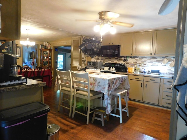 kitchen with ceiling fan with notable chandelier, tasteful backsplash, black microwave, range, and dark wood-style flooring