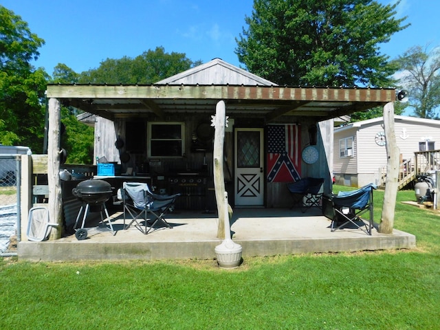 back of property with a lawn, metal roof, and an attached carport