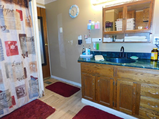 bathroom featuring baseboards, wood finished floors, and vanity