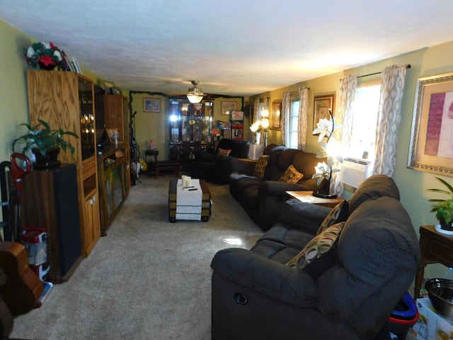 living area with a ceiling fan and carpet