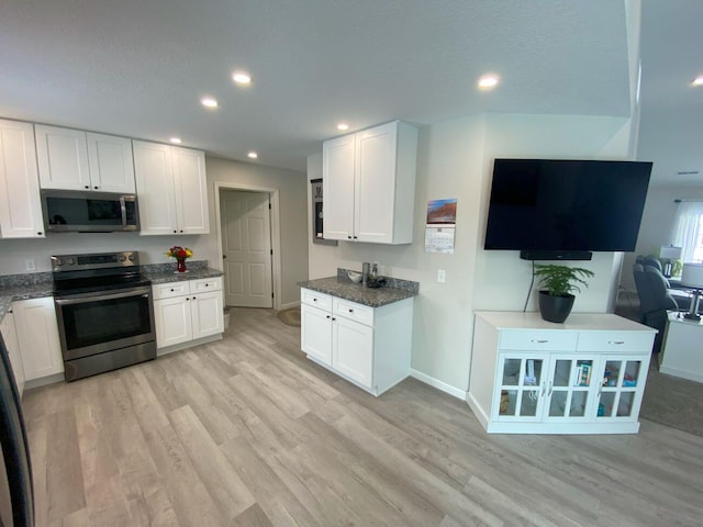 kitchen featuring baseboards, appliances with stainless steel finishes, light wood-type flooring, white cabinetry, and recessed lighting