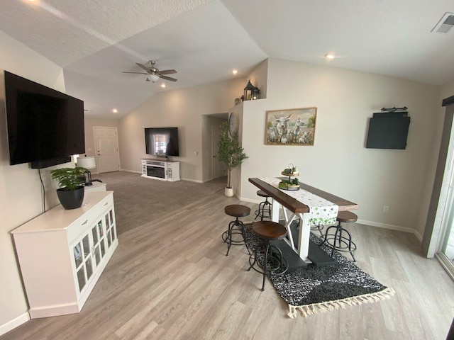 dining room with baseboards, visible vents, a ceiling fan, vaulted ceiling, and light wood-style floors