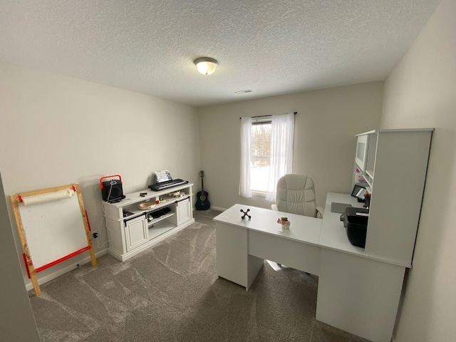 office with a textured ceiling and dark colored carpet