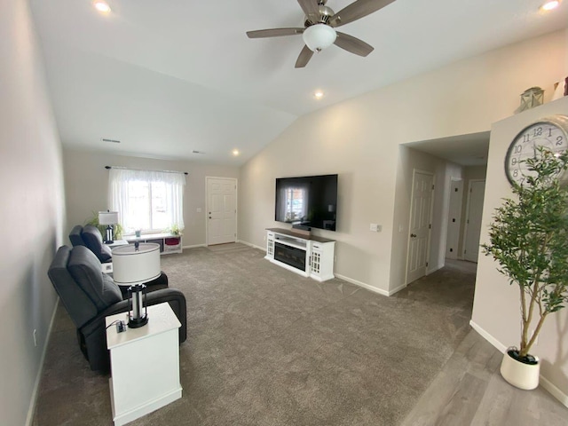 living room featuring dark carpet, vaulted ceiling, baseboards, and a ceiling fan