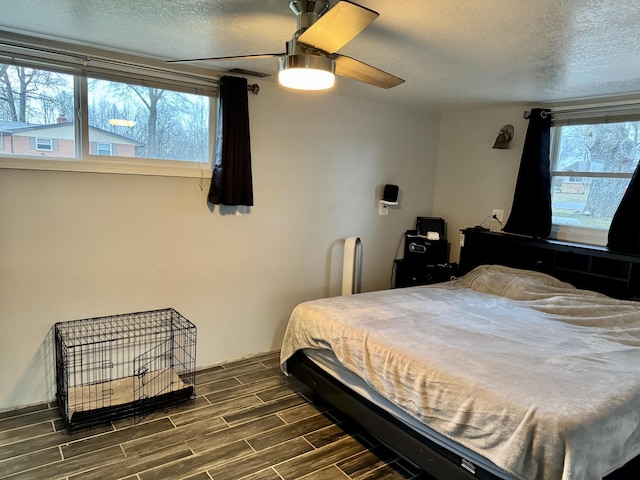 bedroom with a textured ceiling, ceiling fan, and wood finish floors