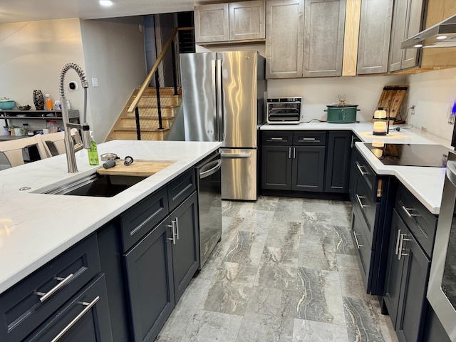 kitchen featuring under cabinet range hood, stainless steel appliances, a sink, marble finish floor, and light countertops