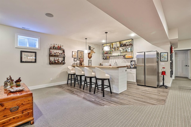 1439 Legacy Ct, Troy, OH 45373 - kitchen with stainless steel refrigerator, light colored carpet, a kitchen breakfast bar, and open shelves