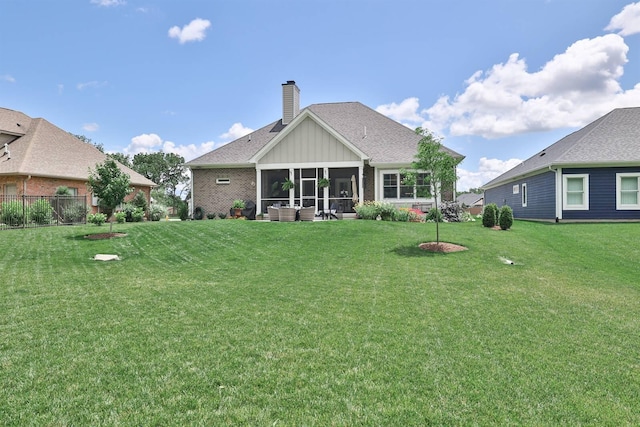 1439 Legacy Ct, Troy, OH 45373 - rear view of house with a yard, a chimney, a sunroom, and board and batten siding