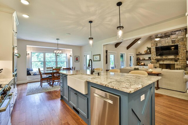 1439 Legacy Ct, Troy, OH 45373 - kitchen featuring appliances with stainless steel finishes, gray cabinetry, open floor plan, light stone counters, and dark wood finished floors