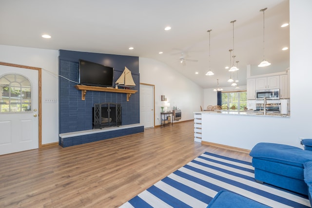 9342 State Route 368, Huntsville, OH 43324 - living room with vaulted ceiling, a ceiling fan, a fireplace, wood finished floors, and recessed lighting