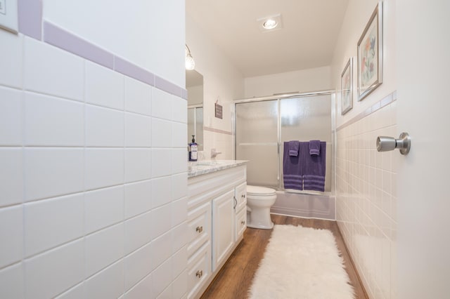 9342 State Route 368, Huntsville, OH 43324 - full bath featuring tile walls, vanity, toilet, combined bath / shower with glass door, and wood finished floors