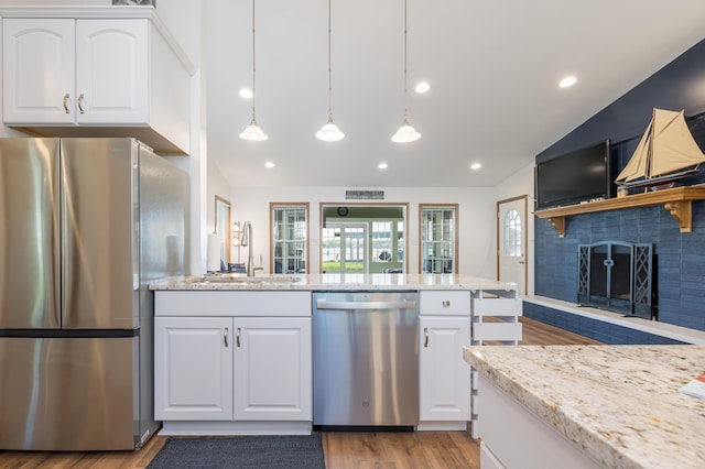 9342 State Route 368, Huntsville, OH 43324 - kitchen with appliances with stainless steel finishes, vaulted ceiling, a sink, a fireplace, and light wood-type flooring