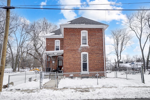 view of front facade featuring a fenced front yard, a gate, and brick siding