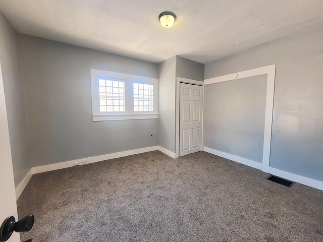 unfurnished bedroom with a closet, carpet flooring, and a textured ceiling