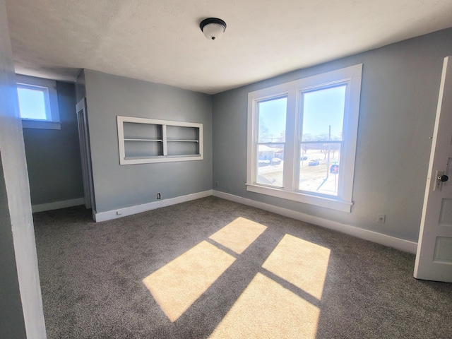 carpeted empty room featuring built in features