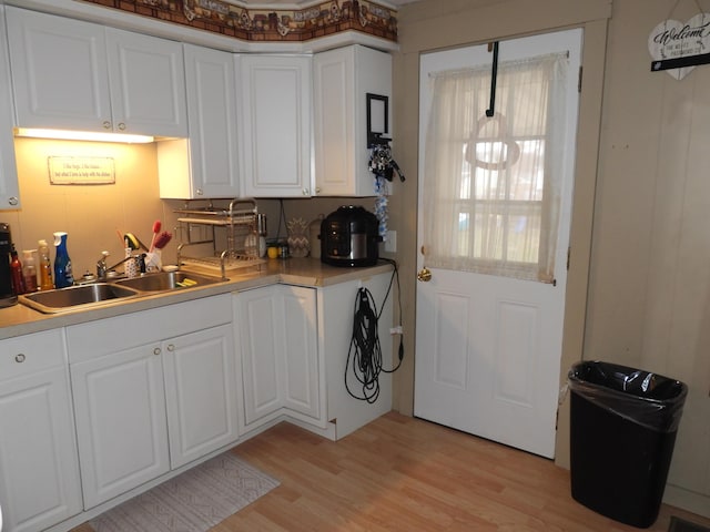 kitchen featuring white cabinetry, sink, and light hardwood / wood-style floors