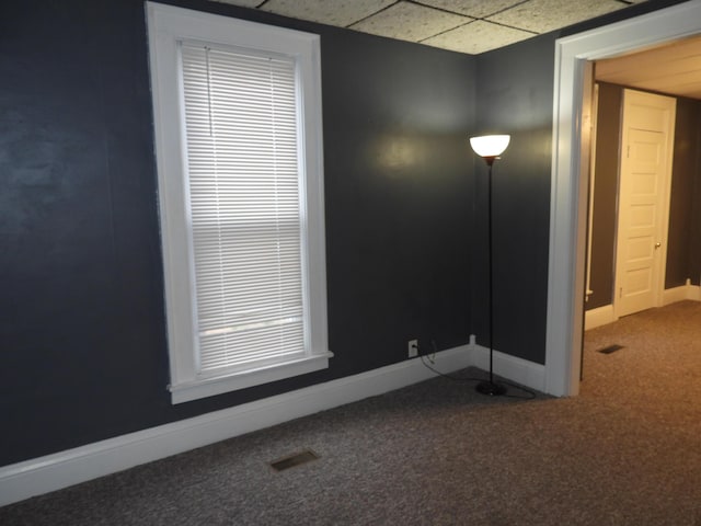 carpeted spare room featuring a paneled ceiling