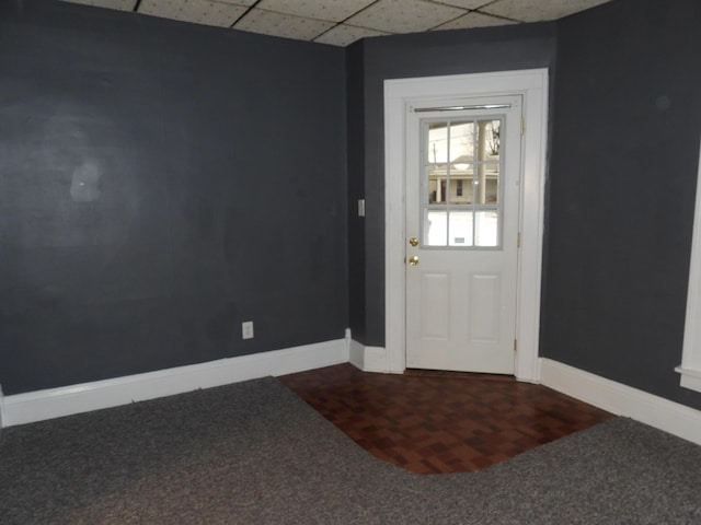 doorway to outside featuring dark parquet flooring and a paneled ceiling