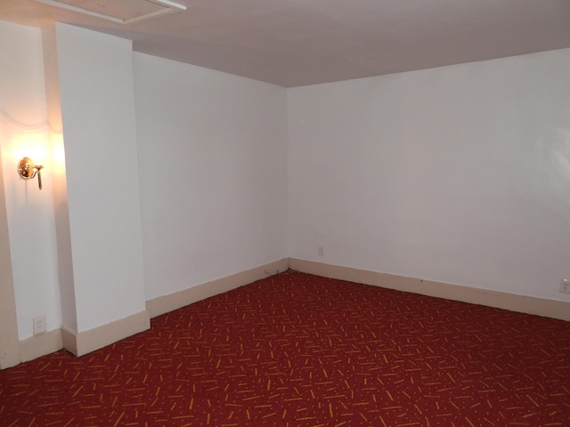 spare room with dark carpet