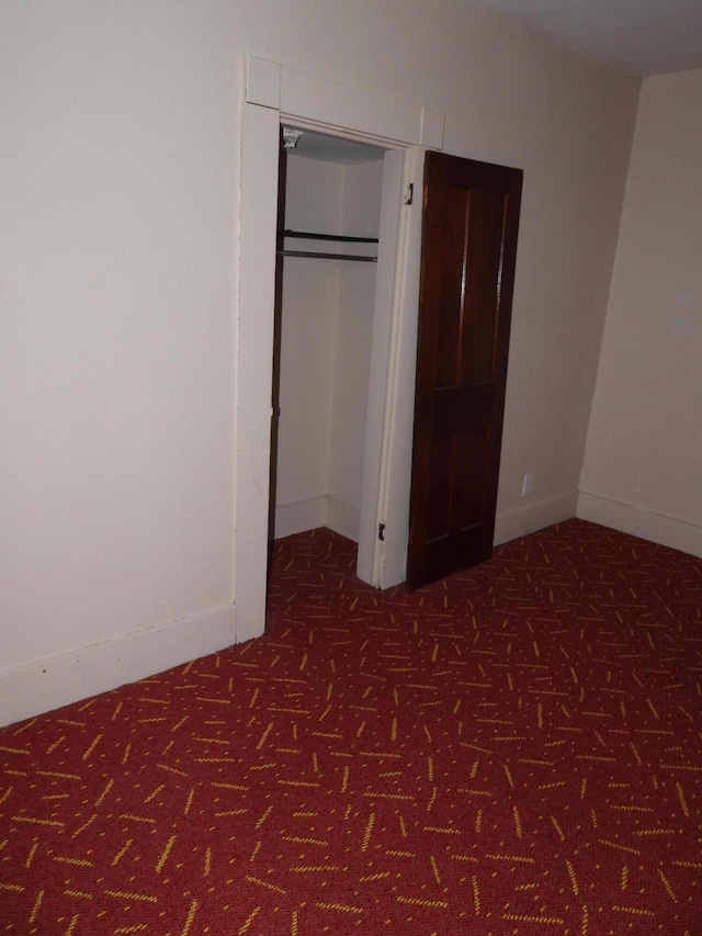 unfurnished bedroom with dark colored carpet