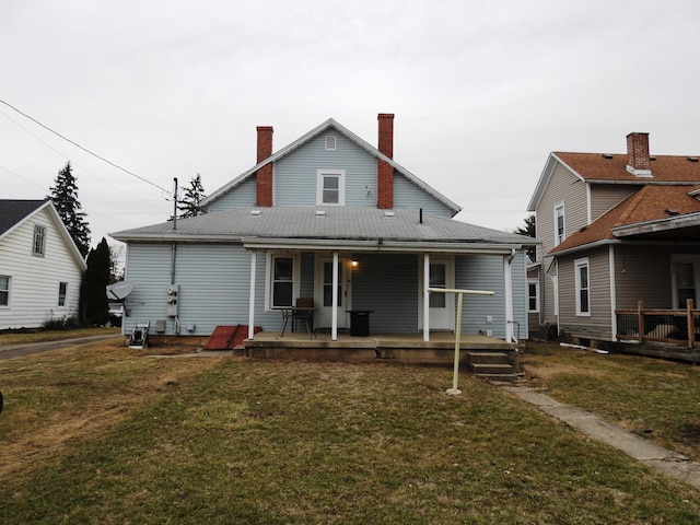 rear view of property featuring a lawn