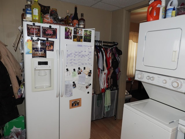 laundry room featuring hardwood / wood-style flooring and stacked washing maching and dryer