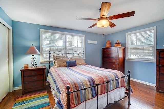 bedroom featuring a ceiling fan, a closet, baseboards, and wood finished floors