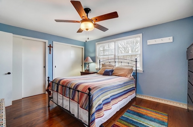 bedroom with multiple closets, a ceiling fan, and wood finished floors