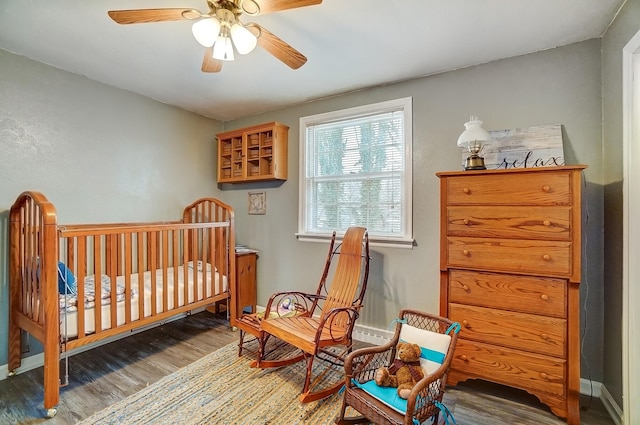 bedroom with ceiling fan, baseboards, and wood finished floors