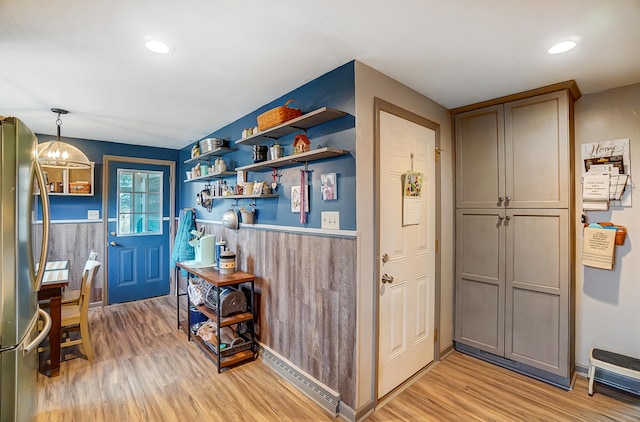 entryway featuring recessed lighting, wainscoting, light wood-style flooring, and an inviting chandelier