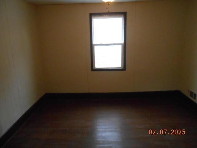 empty room featuring visible vents and wood finished floors