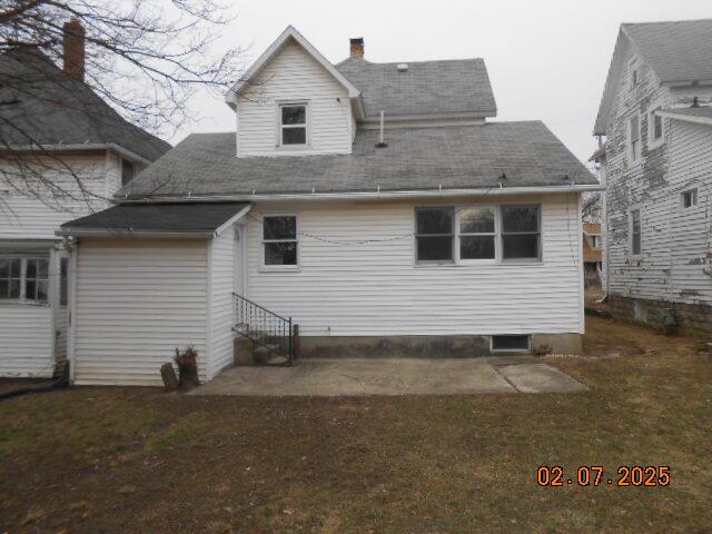 back of house featuring entry steps and a yard