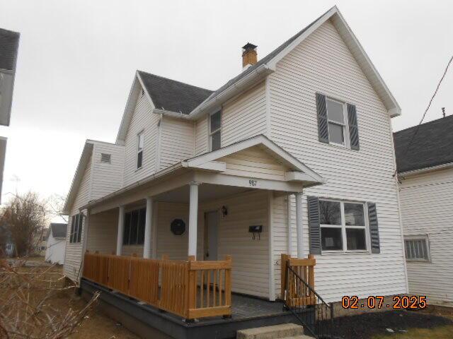 view of front of property featuring covered porch and a chimney