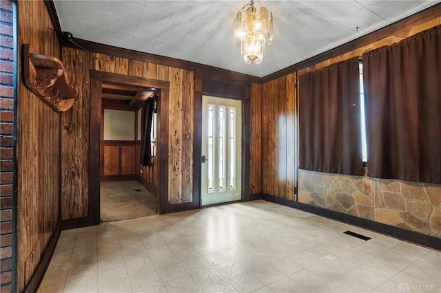 323 Miami St, Piqua, OH 45356 - spare room featuring wood walls, light floors, baseboards, and a chandelier