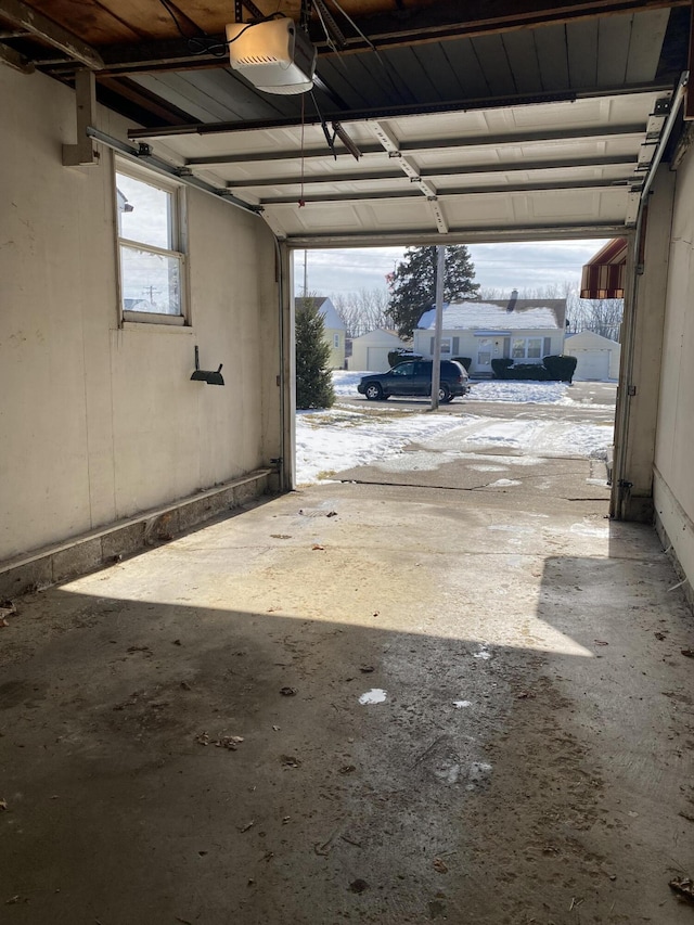 snow covered garage with a garage door opener