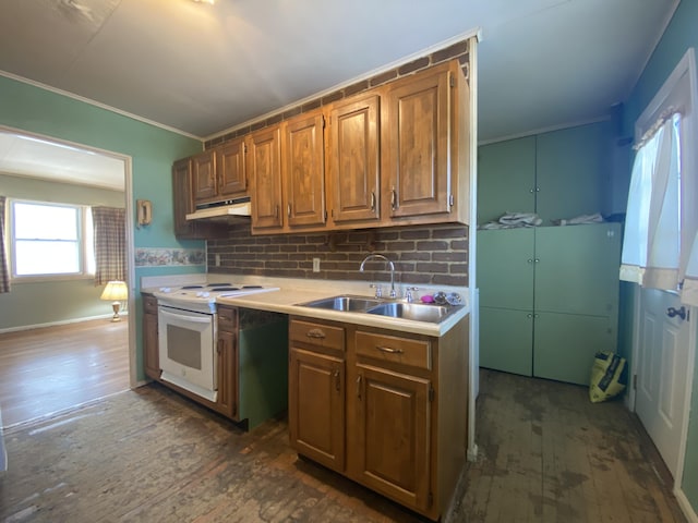 kitchen with white electric range oven, brown cabinets, dark wood-style flooring, light countertops, and a sink