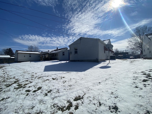 view of snow covered back of property