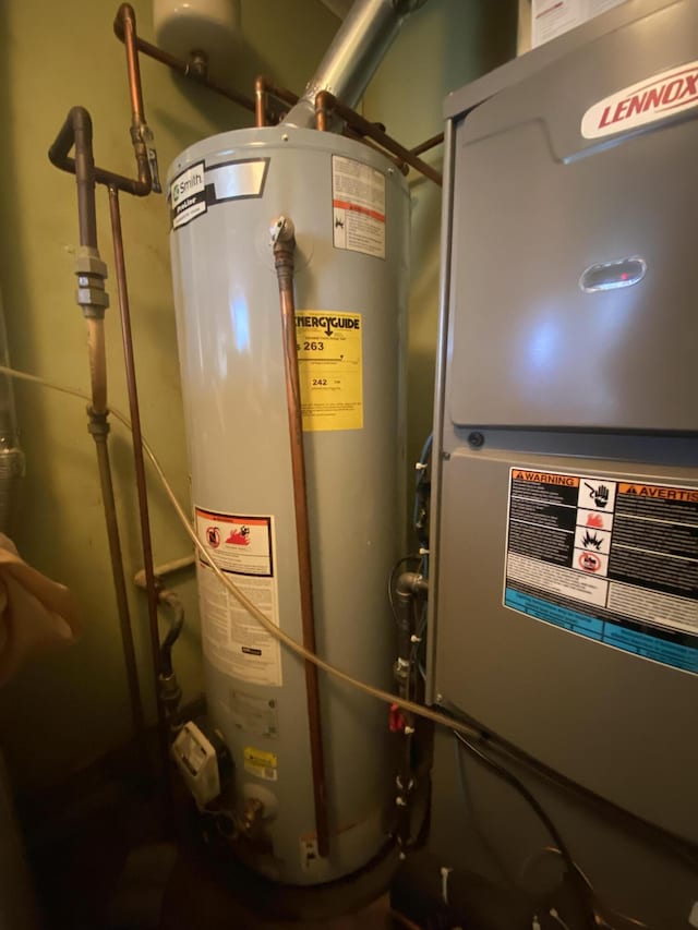 utility room featuring heating unit and water heater