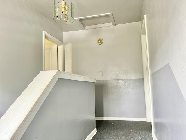 hallway with an upstairs landing, attic access, and baseboards